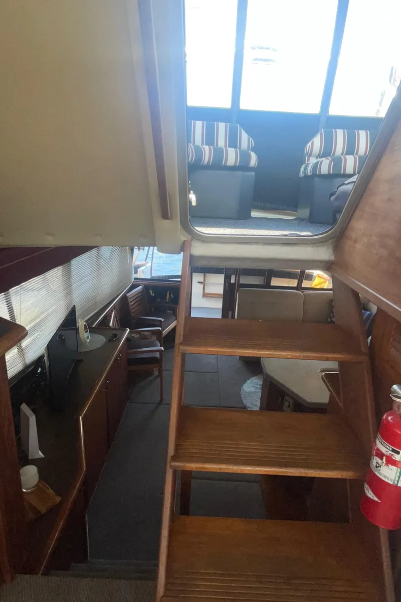 Slide: The Image of Interior view of 1992 Bayliner 4588 Pilothouse with wooden stairs and seating area. - 21