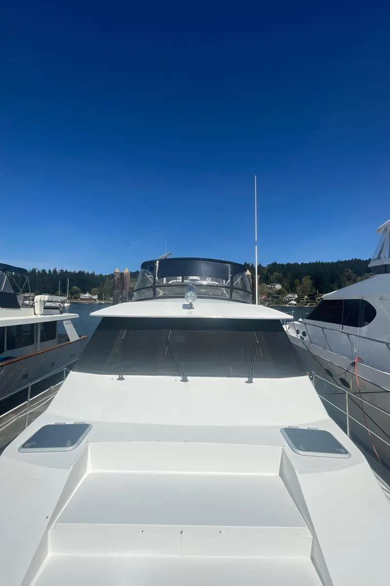 Slide: The Image of 1992 Bayliner 4588 Pilothouse yacht docked under clear blue sky. - 3