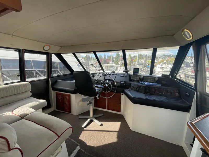 Slide: The Image of 1992 Bayliner 4588 Pilothouse interior with helm, seating, and panoramic windows. - 44