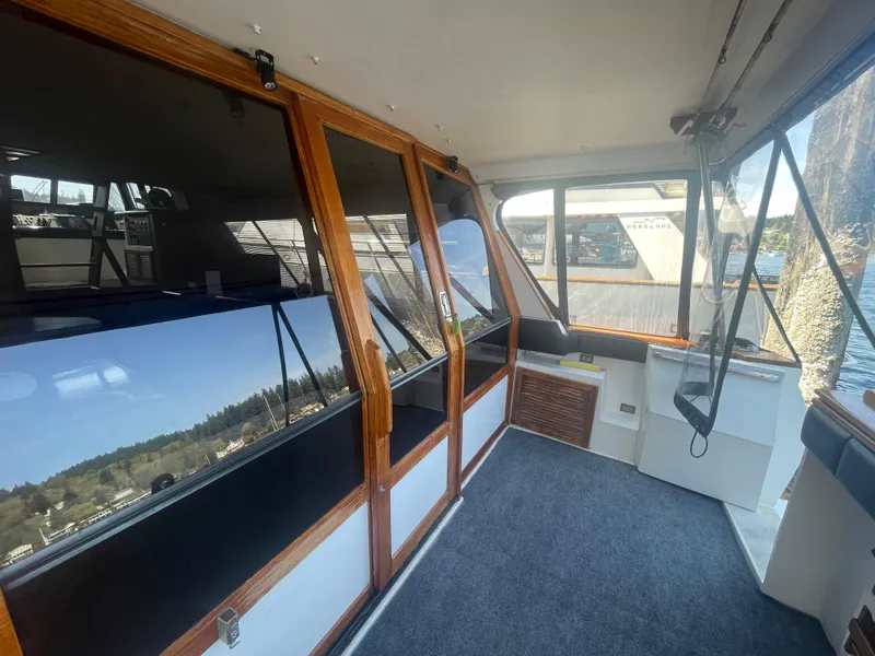 Slide: The Image of 1992 Bayliner 4588 Pilothouse interior with wood accents and large windows. - 5