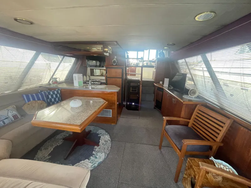 Slide: The Image of 1992 Bayliner 4588 Pilothouse interior with dining area, seating, and helm station. - 7