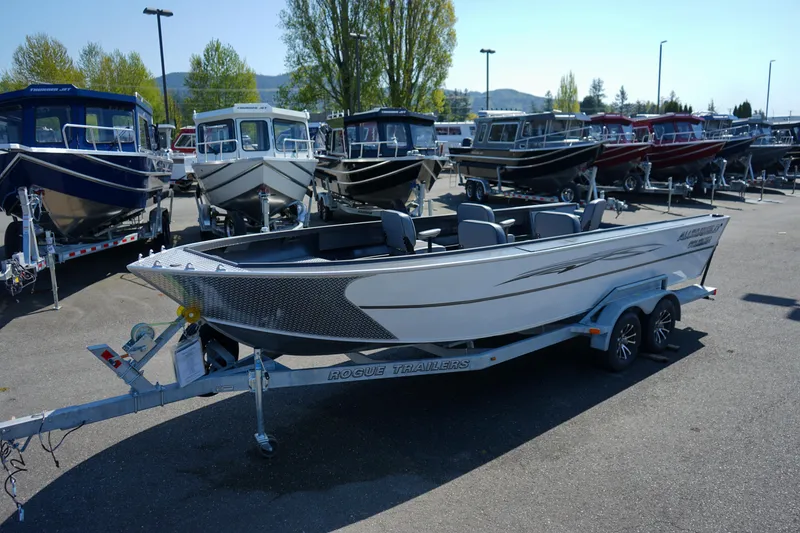 Slide: The Image of 2025 Alumaweld Columbia 23 boat on trailer, parked in a lot with other boats. - 0