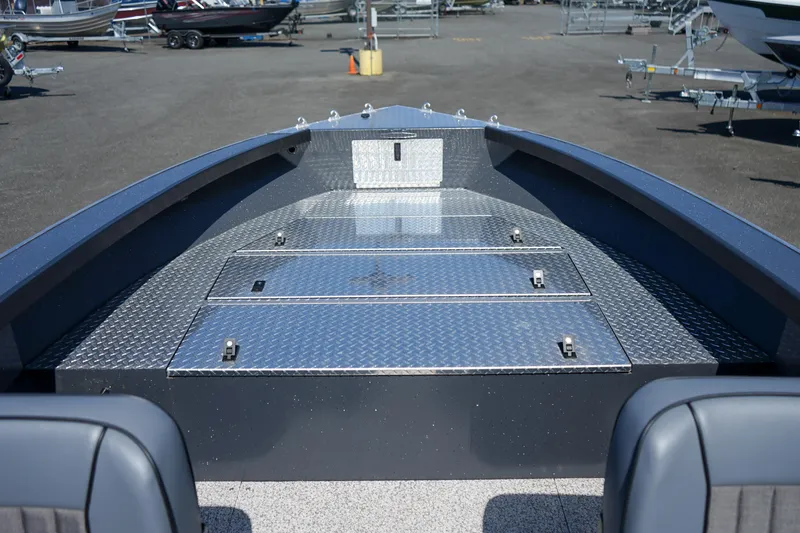 Slide: The Image of 2025 Alumaweld Columbia 23 boat deck with storage compartments, parked in a marina. - 16
