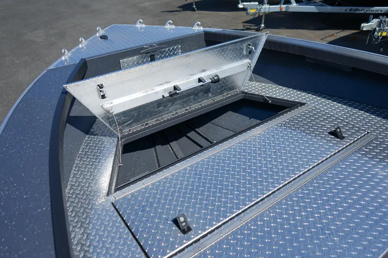 Slide: The Image of 2025 Alumaweld Columbia 23 boat with open storage compartment on diamond plate deck. - 19