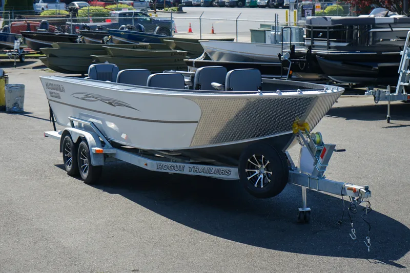 Slide: The Image of 2025 Alumaweld Columbia 23 boat on trailer, parked outdoors in a dealership lot. - 23