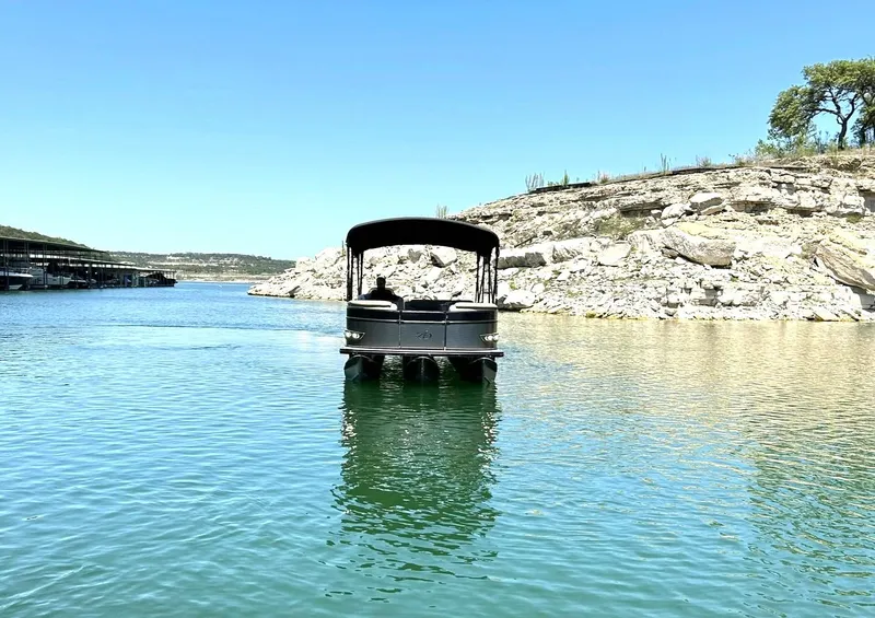 Slide: The Image of 2020 Avalon Catalina 2585 VRB pontoon boat on a serene lake with rocky shoreline. - 10