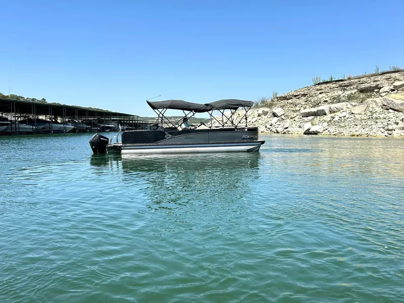 Slide: The Image of 2020 Avalon Catalina 2585 VRB pontoon boat on a serene lake with rocky shoreline. - 13