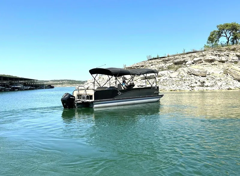 Slide: The Image of 2020 Avalon Catalina 2585 VRB pontoon boat on a serene lake with rocky shoreline. - 14