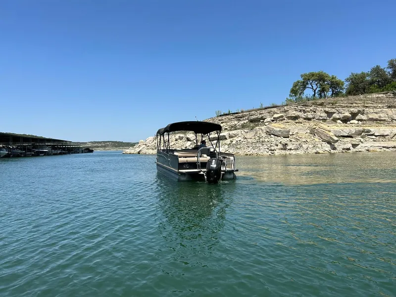 Slide: The Image of 2020 Avalon Catalina 2585 VRB pontoon boat on a serene lake with rocky shoreline. - 17