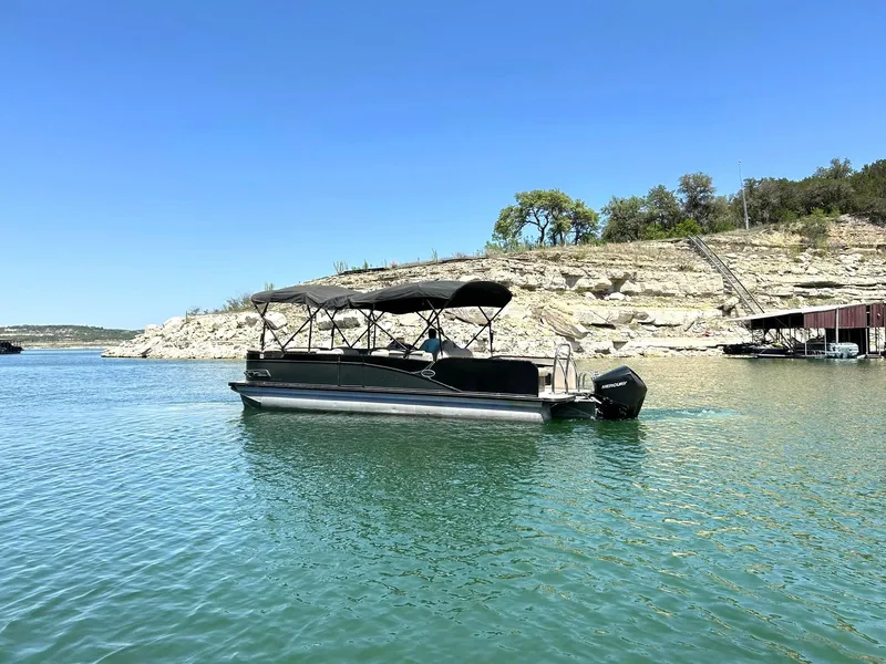 Slide: The Image of 2020 Avalon Catalina 2585 VRB pontoon boat on a serene lake with rocky shoreline. - 19