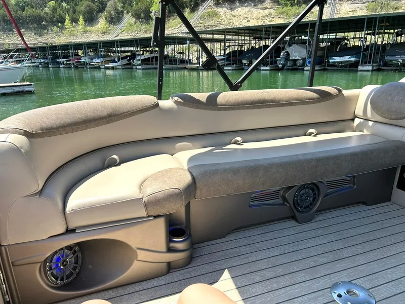 Slide: The Image of 2020 Avalon Catalina 2585 VRB boat interior with plush seating and scenic marina backdrop. - 22