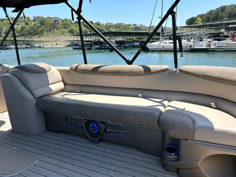 Slide: The Image of 2020 Avalon Catalina 2585 VRB boat interior with cushioned seating and scenic marina view. - 24