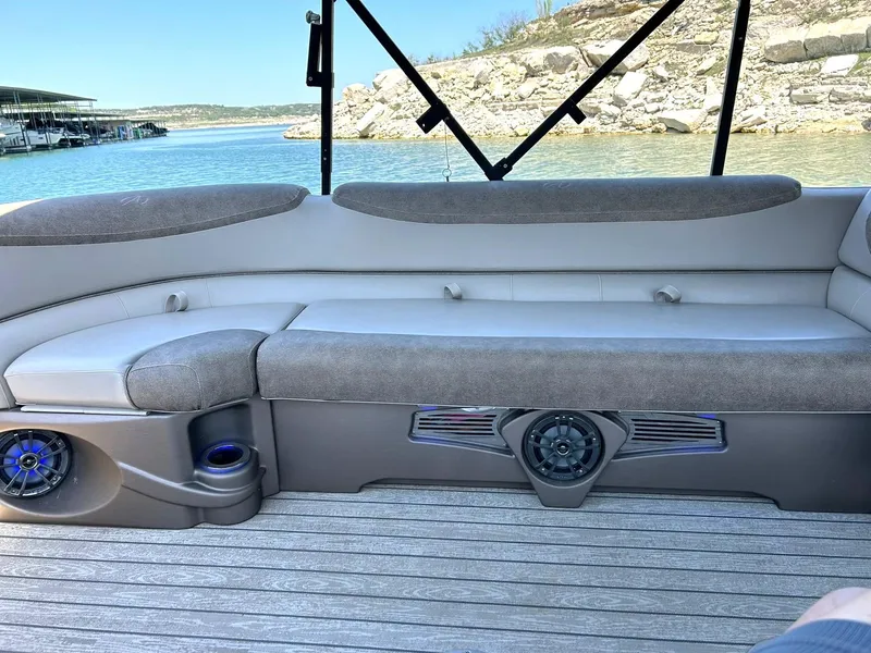 Slide: The Image of 2020 Avalon Catalina 2585 VRB boat interior with cushioned seating and scenic lake view. - 31