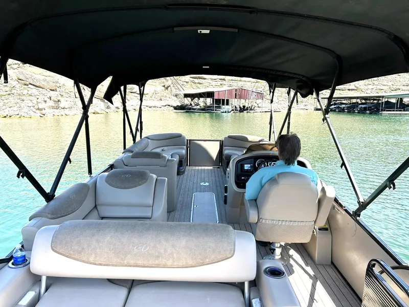 Slide: The Image of 2020 Avalon Catalina 2585 VRB pontoon boat on a lake, with a person steering. - 32