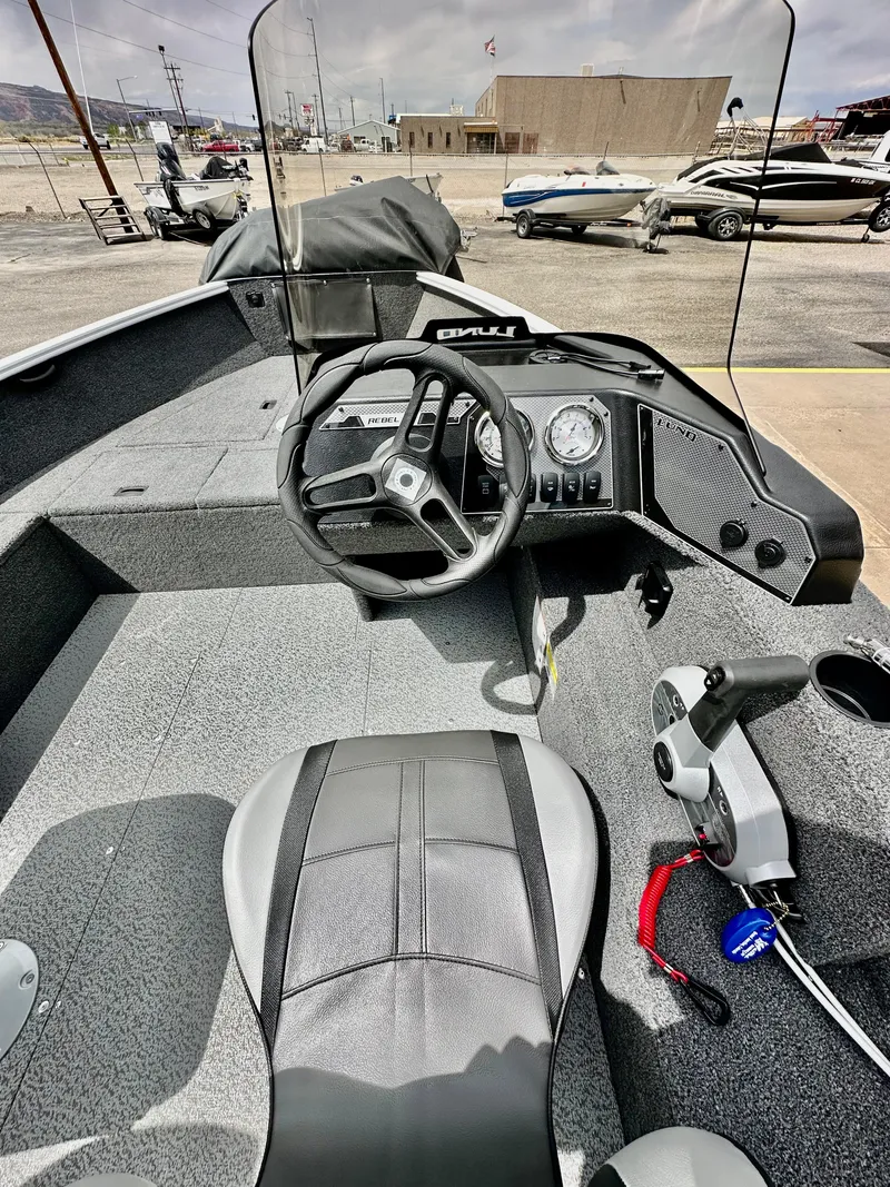 Slide: The Image of 2025 Lund 1650 Rebel XL Sport boat interior with steering wheel and control panel. - 11
