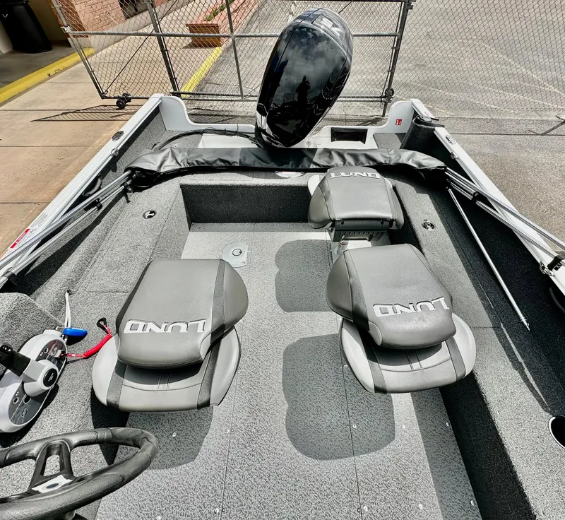 Slide: The Image of 2025 Lund 1650 Rebel XL Sport boat interior with seating and steering wheel. - 7