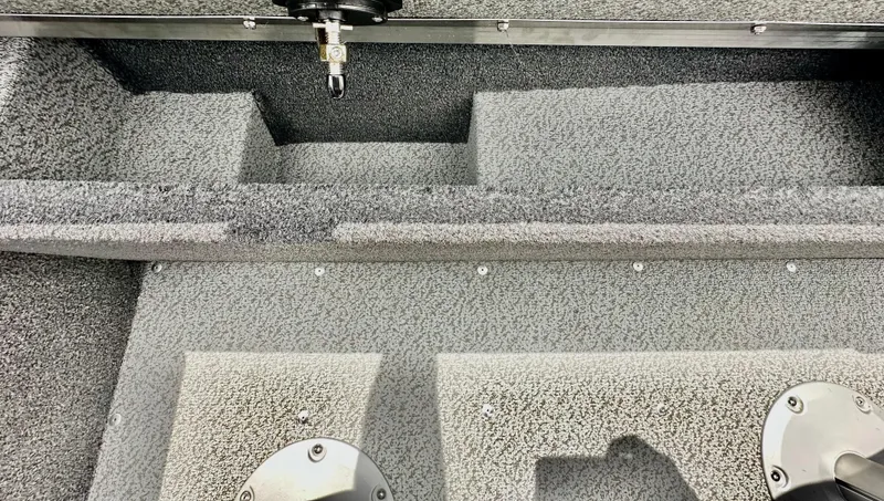 Slide: The Image of 2025 Lund 1650 Rebel XL Sport boat interior with textured flooring and seating compartments. - 9