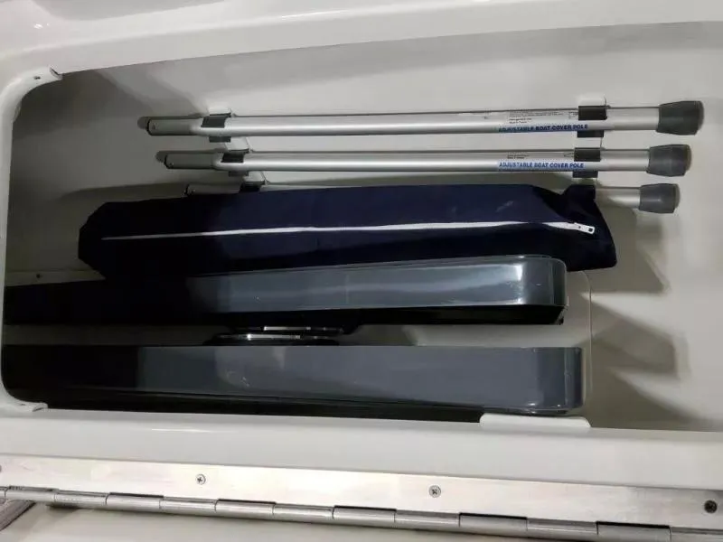 Slide: The Image of Storage compartment in a 2021 Formula 350 Crossover Bowrider I/O with boat cover poles. - 18