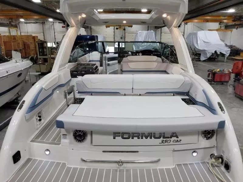 Slide: The Image of 2021 Formula 350 Crossover Bowrider I/O in a showroom, showcasing sleek design and spacious seating. - 8
