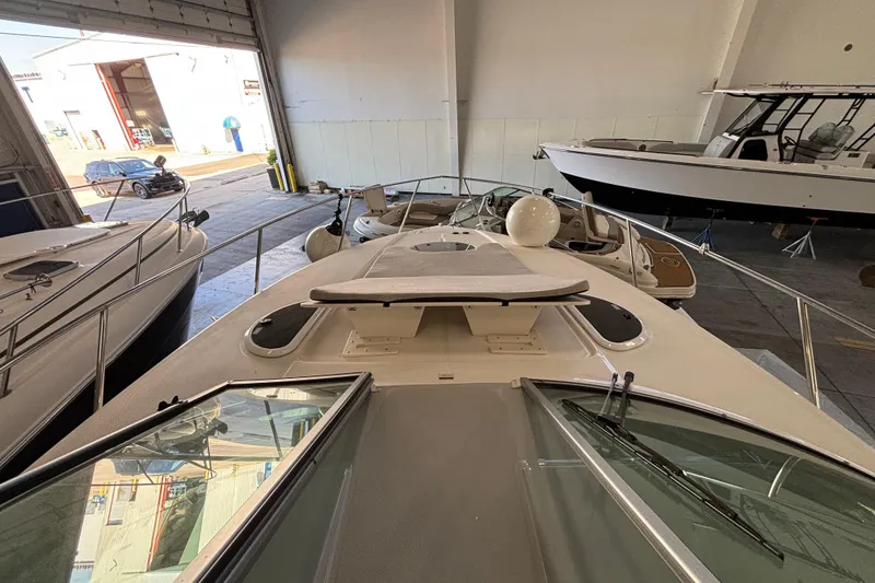 Slide: The Image of 2023 Regal 33 Express boat with sunpad, docked indoors among other vessels. - 3