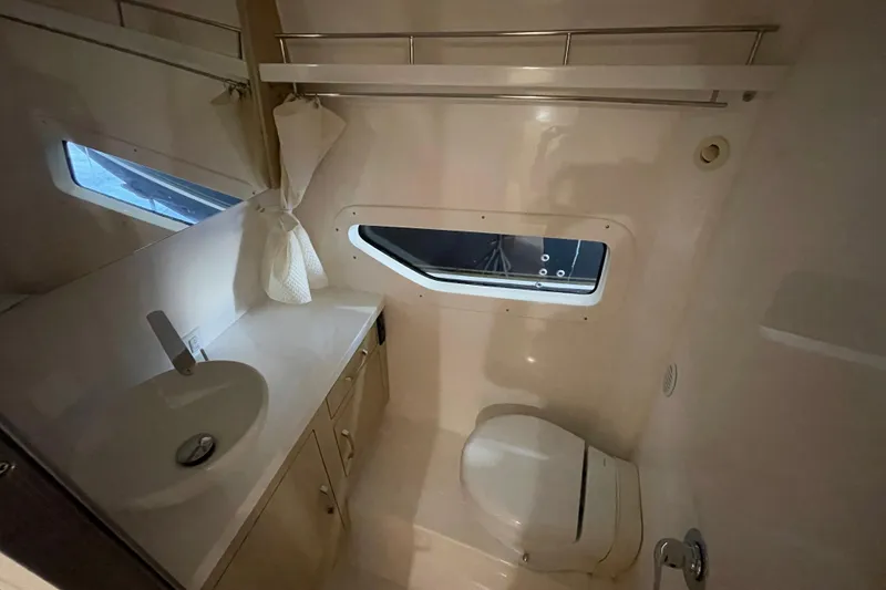 Slide: The Image of 2023 Regal 33 Express boat bathroom with sink, toilet, and window. - 32