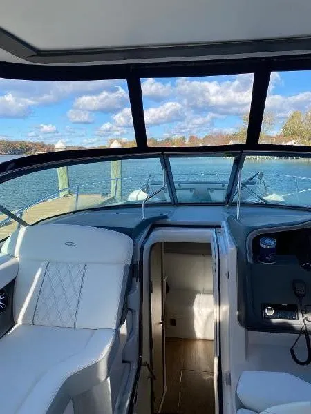 Slide: The Image of 2023 Regal 33 Express boat interior with seating, sink, and helm in a showroom. - 6