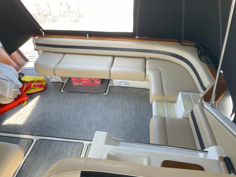 Slide: The Image of Interior of 1990 Sea Ray 390 Express Cruiser with beige seating and carpeted floor. - 10