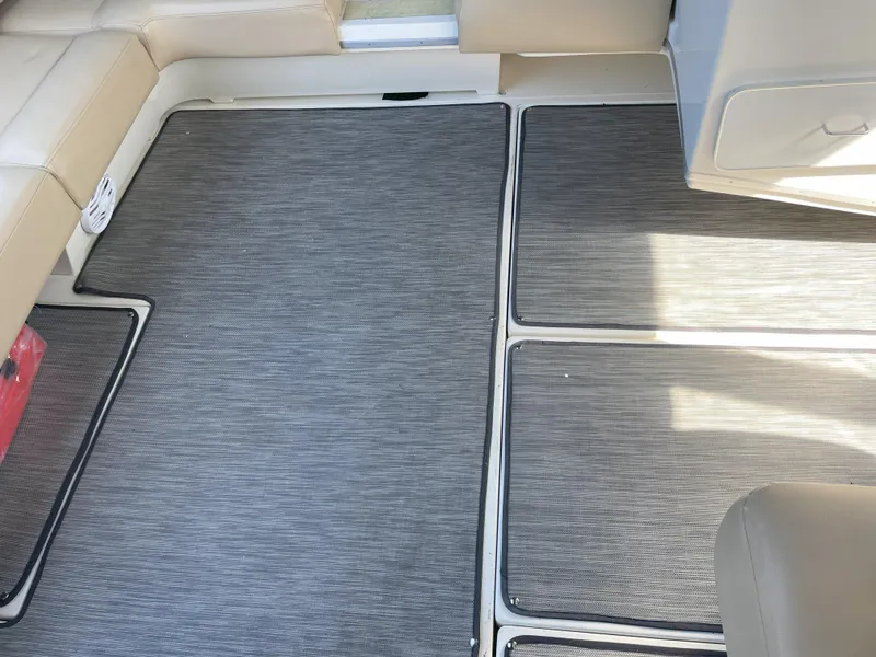 Slide: The Image of 1990 Sea Ray 390 Express Cruiser interior with gray carpet and beige seating. - 11