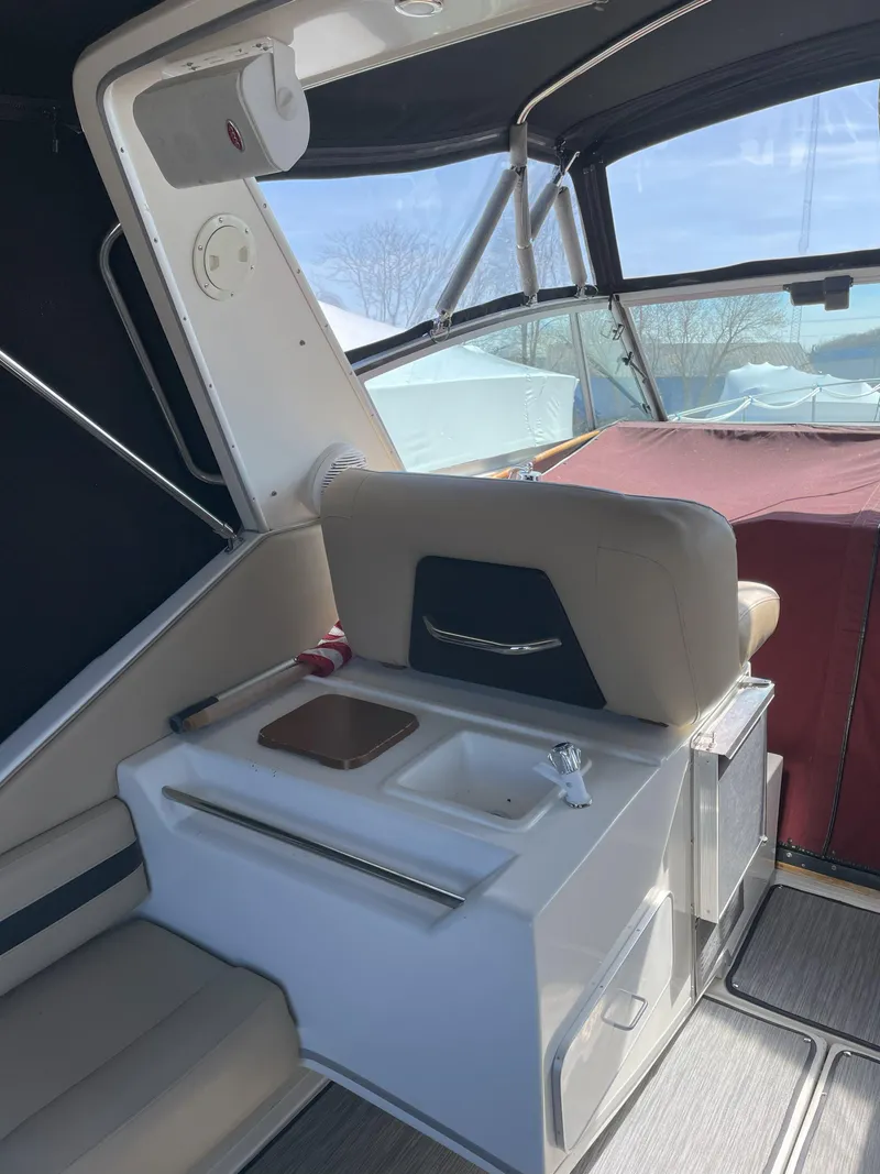 Slide: The Image of 1990 Sea Ray 390 Express Cruiser interior with seating and kitchenette. - 14