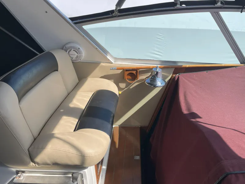 Slide: The Image of Interior of 1990 Sea Ray 390 Express Cruiser with seating and covered dashboard. - 16