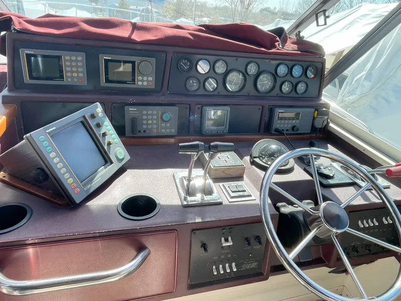 Slide: The Image of 1990 Sea Ray 390 Express Cruiser helm with steering wheel, gauges, and navigation equipment. - 18