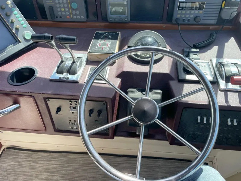 Slide: The Image of 1990 Sea Ray 390 Express Cruiser helm with steering wheel and control panel. - 19