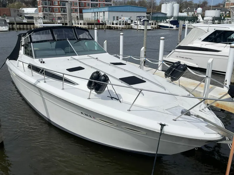 Slide: The Image of 1990 Sea Ray 390 Express Cruiser docked at marina, featuring sleek white design and spacious deck. - 2