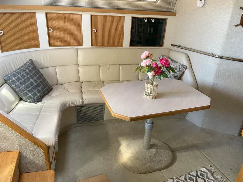 Slide: The Image of Interior of 1990 Sea Ray 390 Express Cruiser with cozy seating and floral centerpiece. - 22