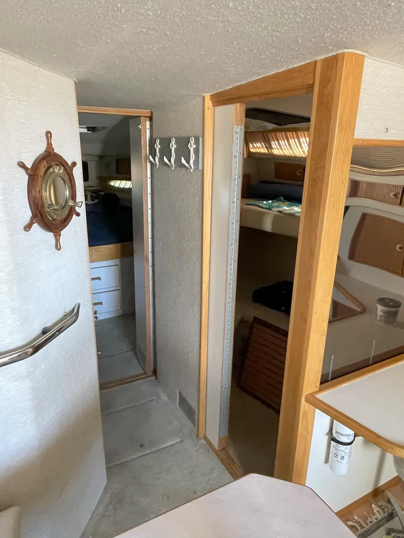 Slide: The Image of Interior of a 1990 Sea Ray 390 Express Cruiser with nautical decor and cozy cabin space. - 28