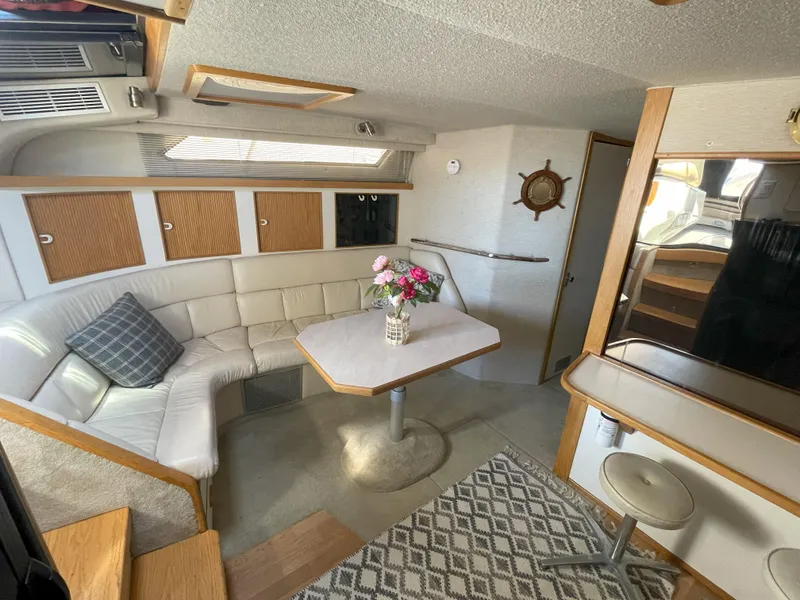Slide: The Image of Interior of 1990 Sea Ray 390 Express Cruiser with cozy seating and dining area. - 29
