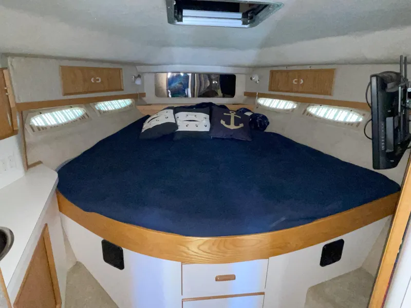Slide: The Image of 1990 Sea Ray 390 Express Cruiser cabin with cozy bed and nautical decor. - 30