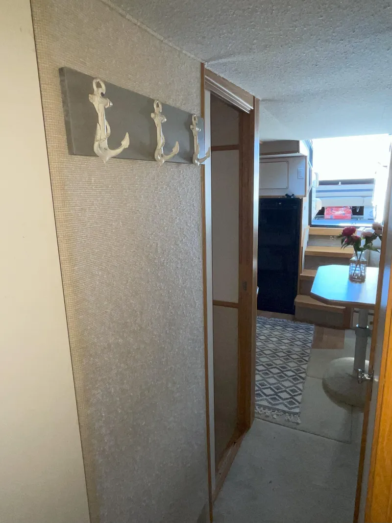 Slide: The Image of Interior of 1990 Sea Ray 390 Express Cruiser with anchor hooks and dining area. - 34