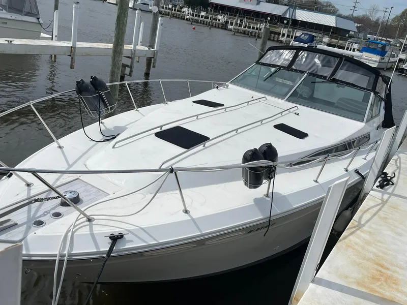 Slide: The Image of 1990 Sea Ray 390 Express Cruiser docked at marina, featuring sleek white design. - 4