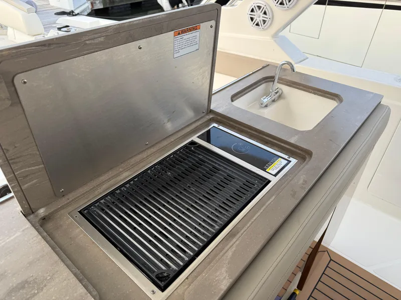 Slide: The Image of Outdoor kitchen on 2023 Tiara Yachts 43 LS, featuring a grill and sink. - 41