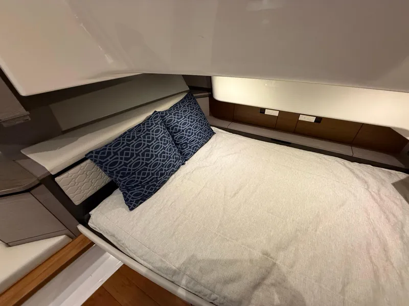 Slide: The Image of 2023 Tiara Yachts 43 LS cabin interior with bed and decorative pillows. - 47