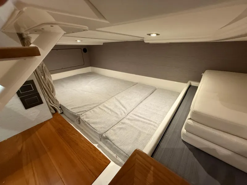 Slide: The Image of 2023 Tiara Yachts 43 LS cabin interior with modern bedding and wooden flooring. - 48