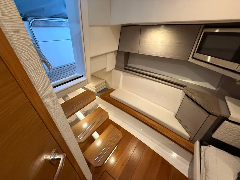 Slide: The Image of 2023 Tiara Yachts 43 LS interior with wooden steps, modern seating, and sleek cabinetry. - 52