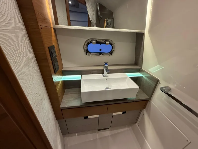 Slide: The Image of 2023 Tiara Yachts 43 LS bathroom with modern sink and porthole window. - 54