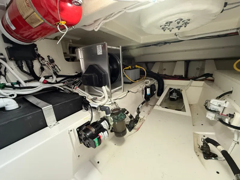 Slide: The Image of Engine room of 2023 Tiara Yachts 43 LS, showcasing mechanical components and fire extinguisher. - 59