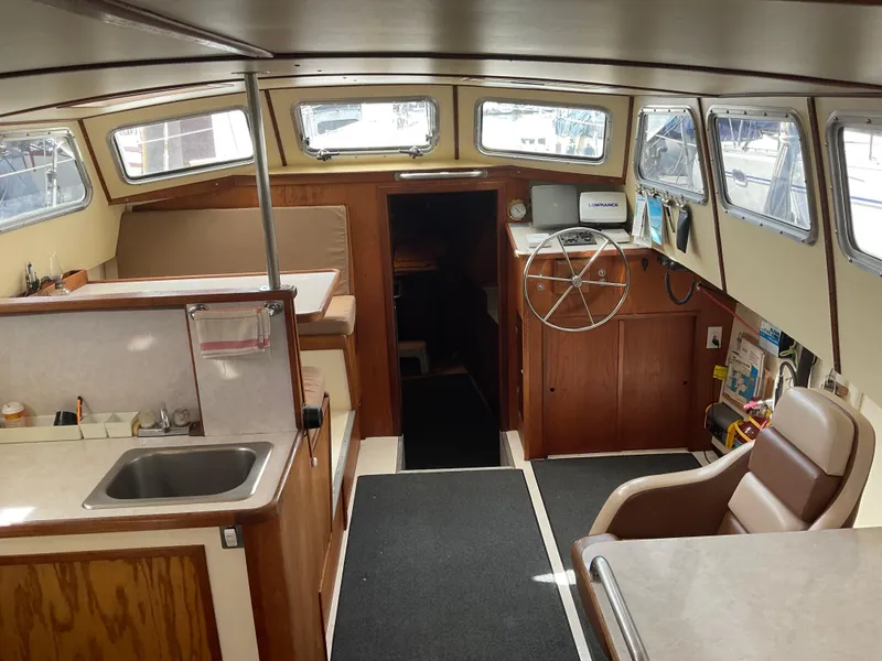 Slide: The Image of Interior of 1980 Kanter Staysail Cutter, featuring helm, seating, and kitchenette. - 12