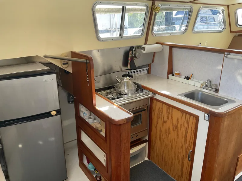 Slide: The Image of 1980 Kanter Staysail Cutter galley with stove, sink, and refrigerator. - 15
