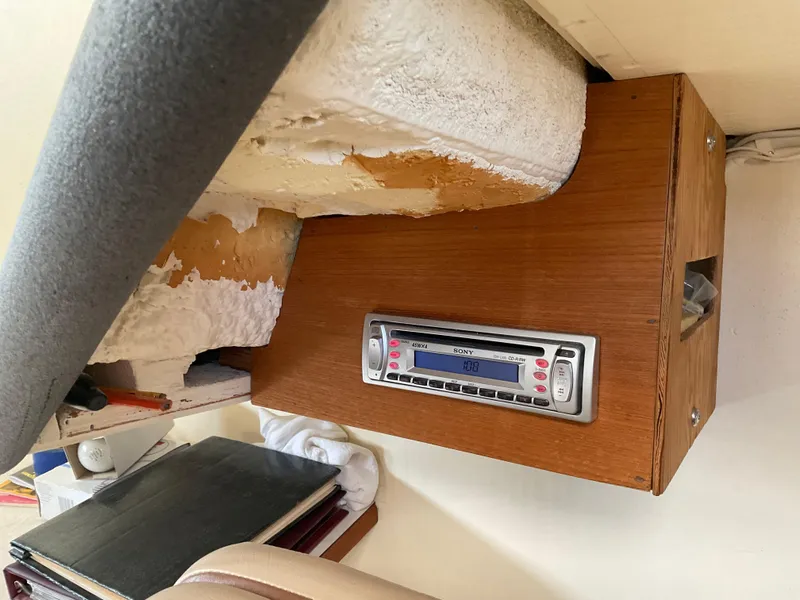 Slide: The Image of 1980 Kanter Staysail Cutter interior with mounted radio and wooden paneling. - 18