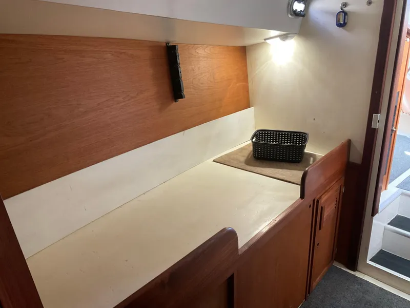 Slide: The Image of 1980 Kanter Staysail Cutter interior with wooden cabinetry and countertop, featuring a small basket. - 27