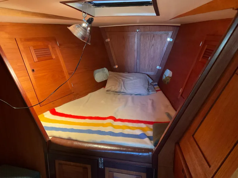 Slide: The Image of Cozy cabin interior of 1980 Kanter Staysail Cutter with wooden finish and striped bedding. - 29